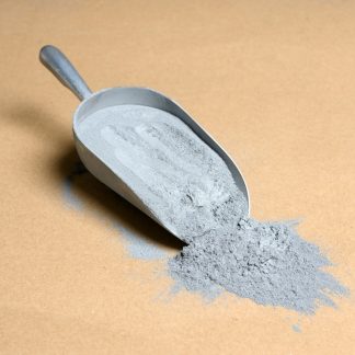 A scoop of gray powder on a beige background.