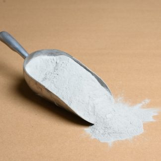 A scoop of white powder on a brown background.