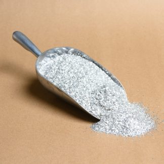 A scoop of silver glitter on a brown surface