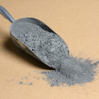 A scoop of gray powder on a brown background.
