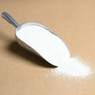 A scoop of white powder on a brown surface.