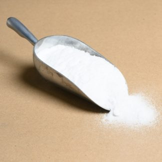 A scoop of white powder on a brown background.