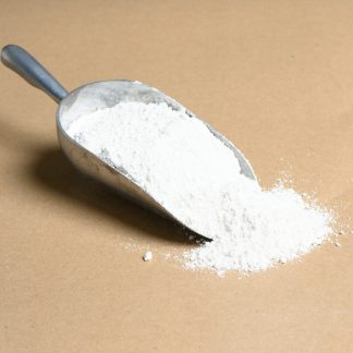 A scoop of white powder on a brown background.