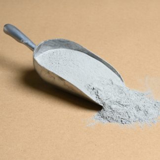 A scoop of gray powder on a beige background.