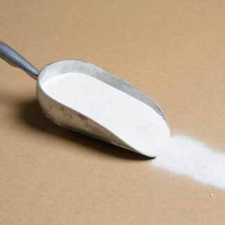 A scoop of white powder on a beige background.