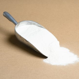 A scoop of white powder on a brown background.