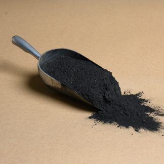 A scoop of black powder on a brown background.