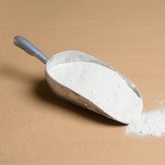 White powder in a metal scoop on a brown background.