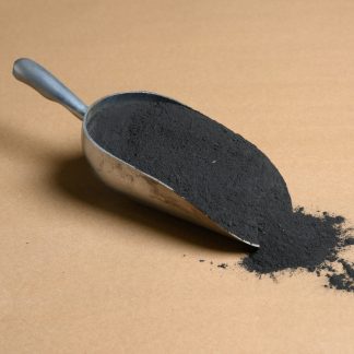 A scoop of black coal on a brown surface.