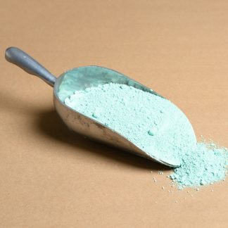 A scoop of green powder on a beige background.