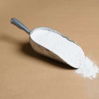 A scoop of Cryolite white powder on a brown surface.