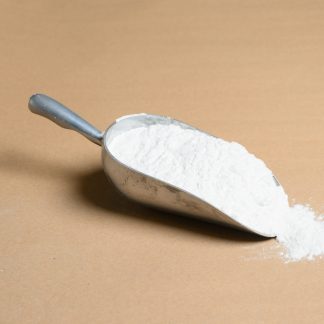 A scoop of white powder on a beige background.