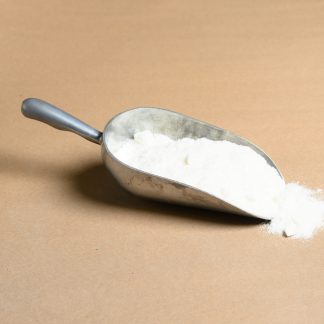 A scoop of flour on a beige background.