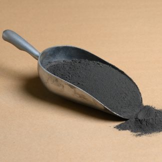 A scoop of black powder on a brown surface.