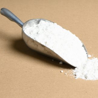A scoop of white powder on a beige background.
