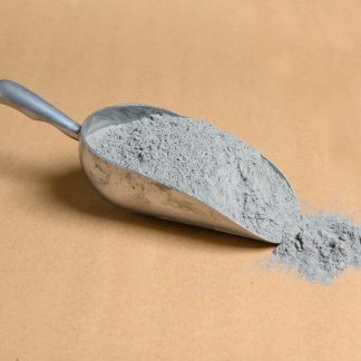 A scoop of gray cement on a beige background.