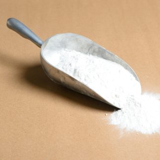 A scoop of Potassium-Chlorate white powder on a brown surface.