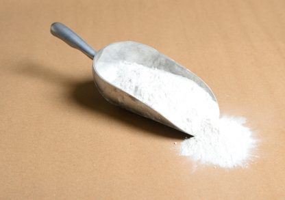 A scoop of Potassium-Chlorate white powder on a brown surface.